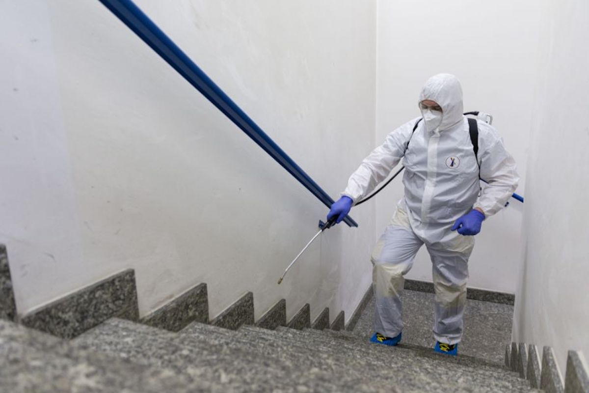 Sanificazione uffici. Foto di un'operaio durante la pulizia di un edificio. 