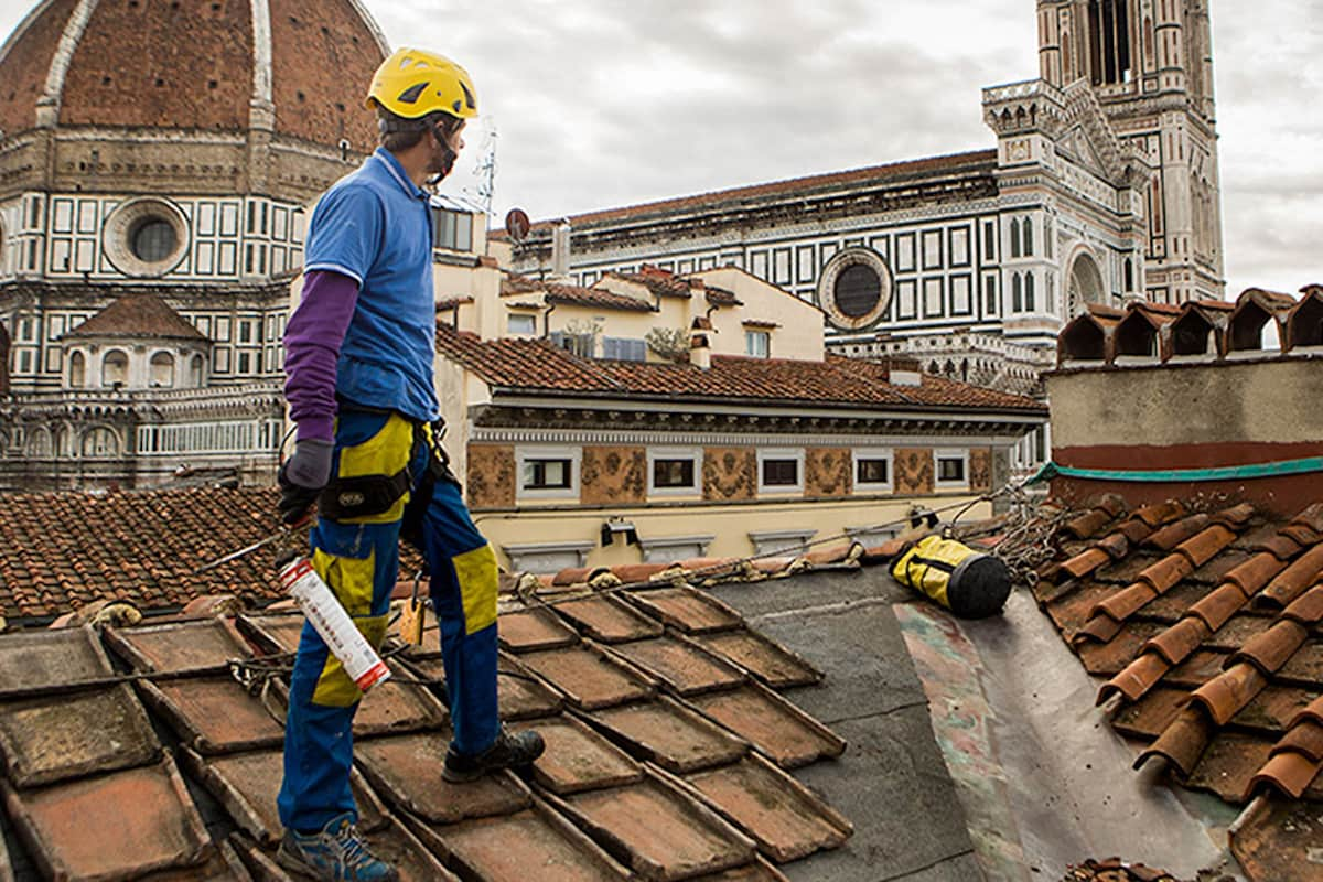 Un operaio acrobatica durante un'operazione di isolamento tetto esistente