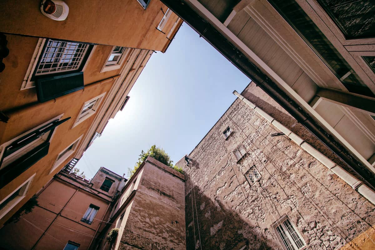 Vista dal basso verso l'alto di condomini alti e moderni, con cielo azzurro, rappresenta l'orario dei lavori nel condominio.