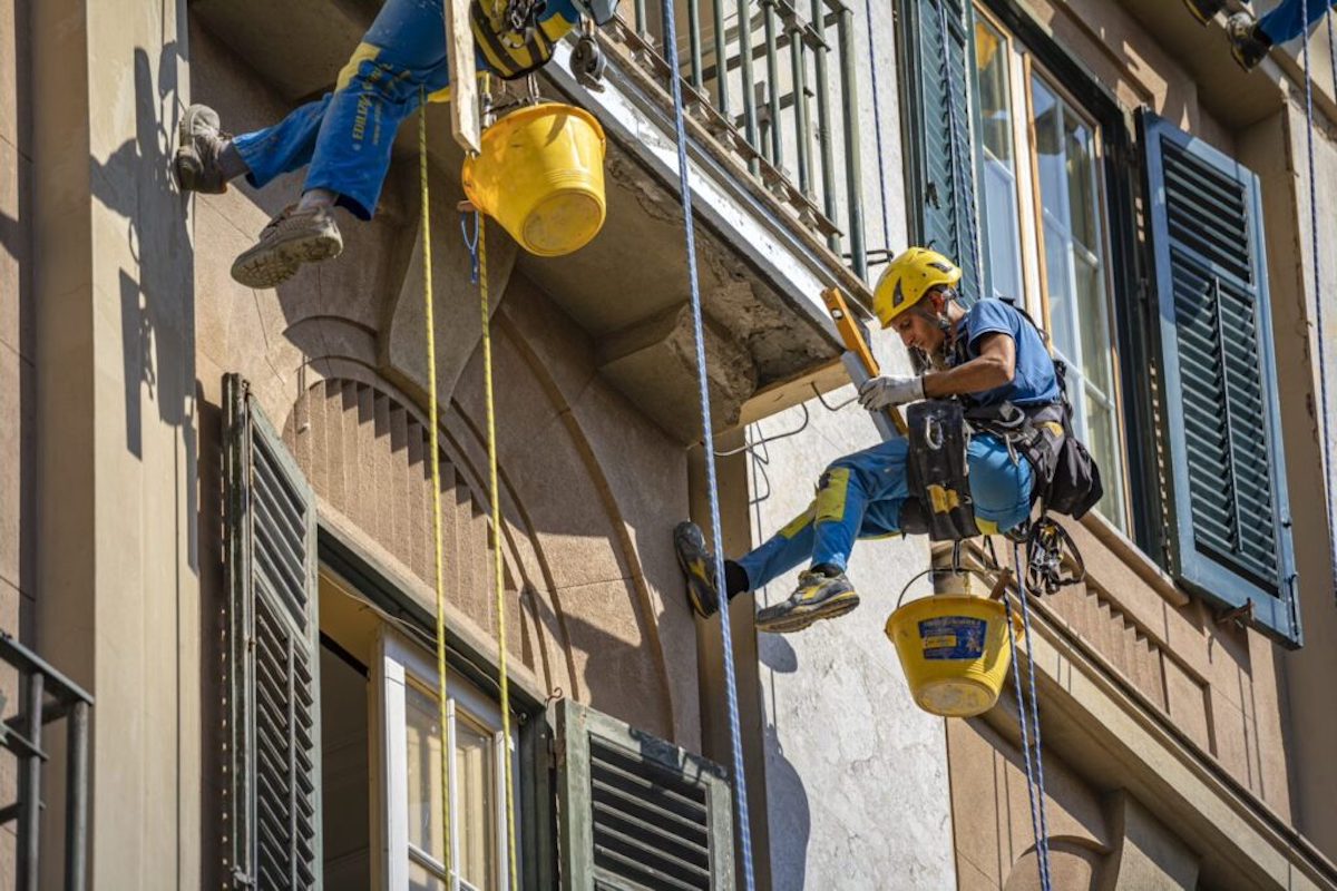 operai acrobatica su fune durante  l'impermeabilizzazione di un terrazzo. 