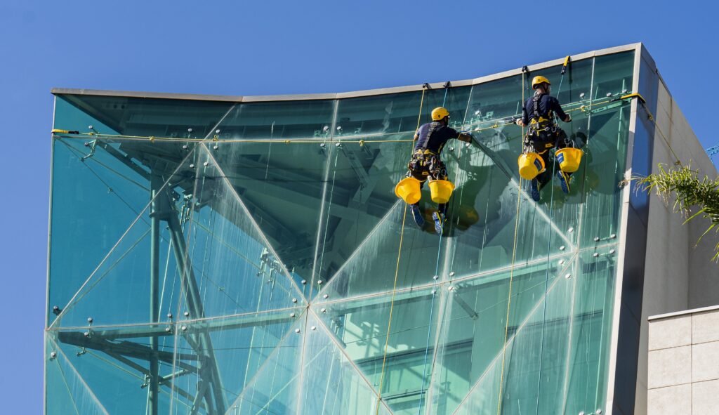 professionisti acrobatica su fune durante pulizia vetri che non si aprono da dentro
