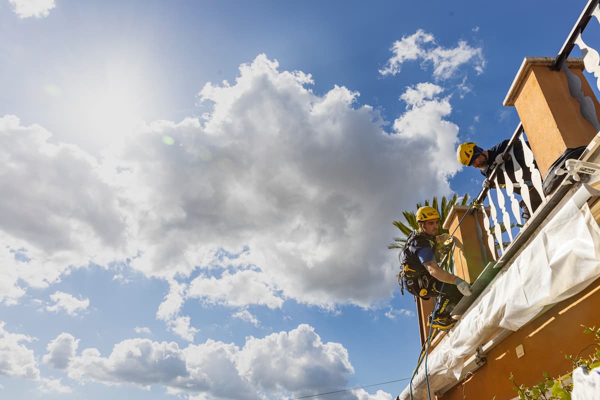 Operai acrobatica su balcone e cielo